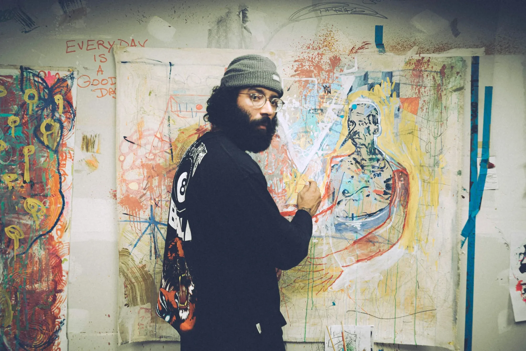 Artist painting a large mural in his studio