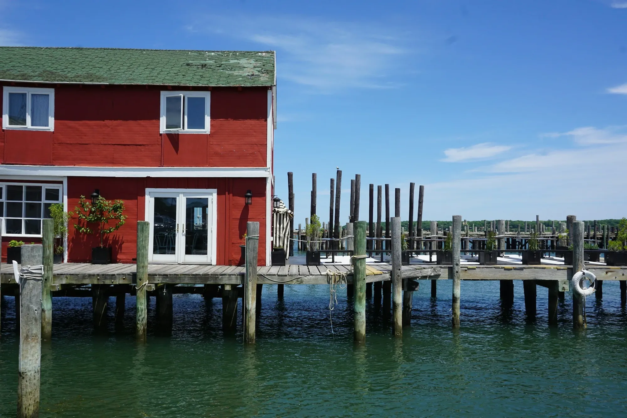 Red wooden building on a pier over the water