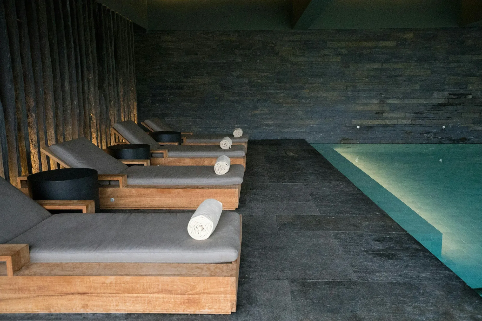 Spa pool with wooden loungers and rolled towels