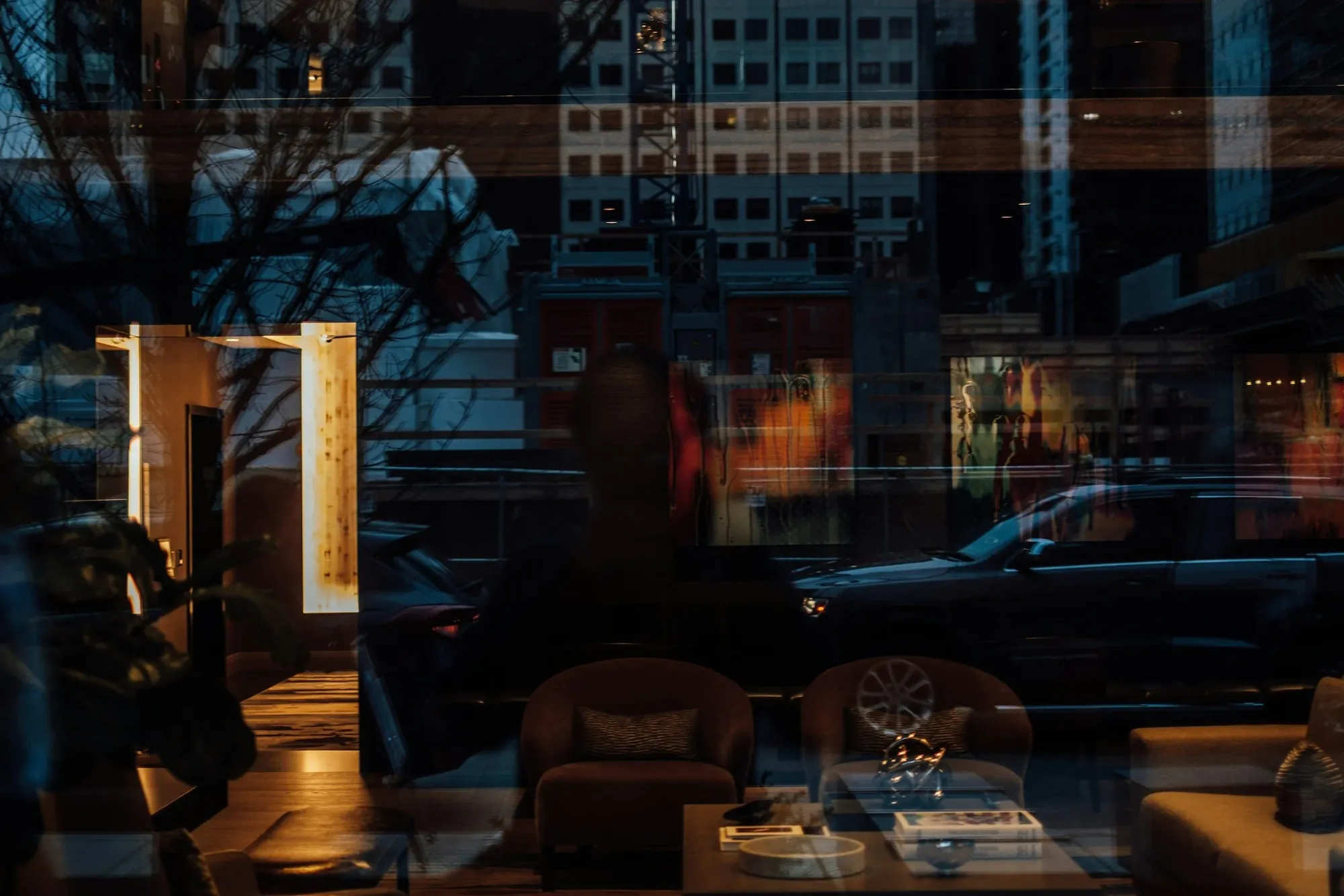 City lights reflected in a hotel lobby window at night