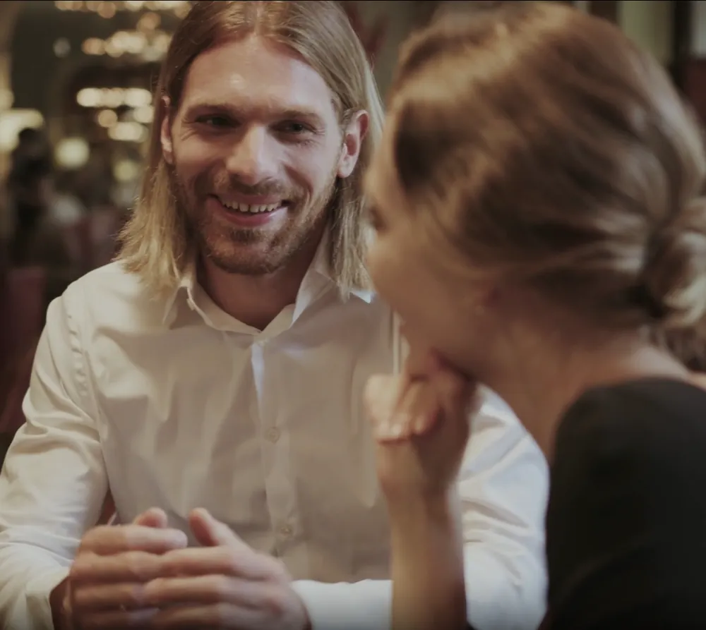 Two people in conversation at a dinner table