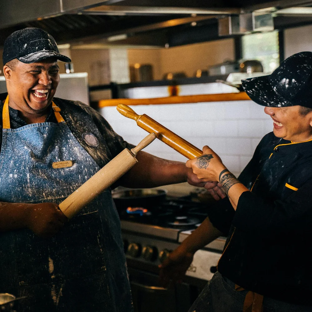 Two smiling chefs working together in a restaurant kitchen